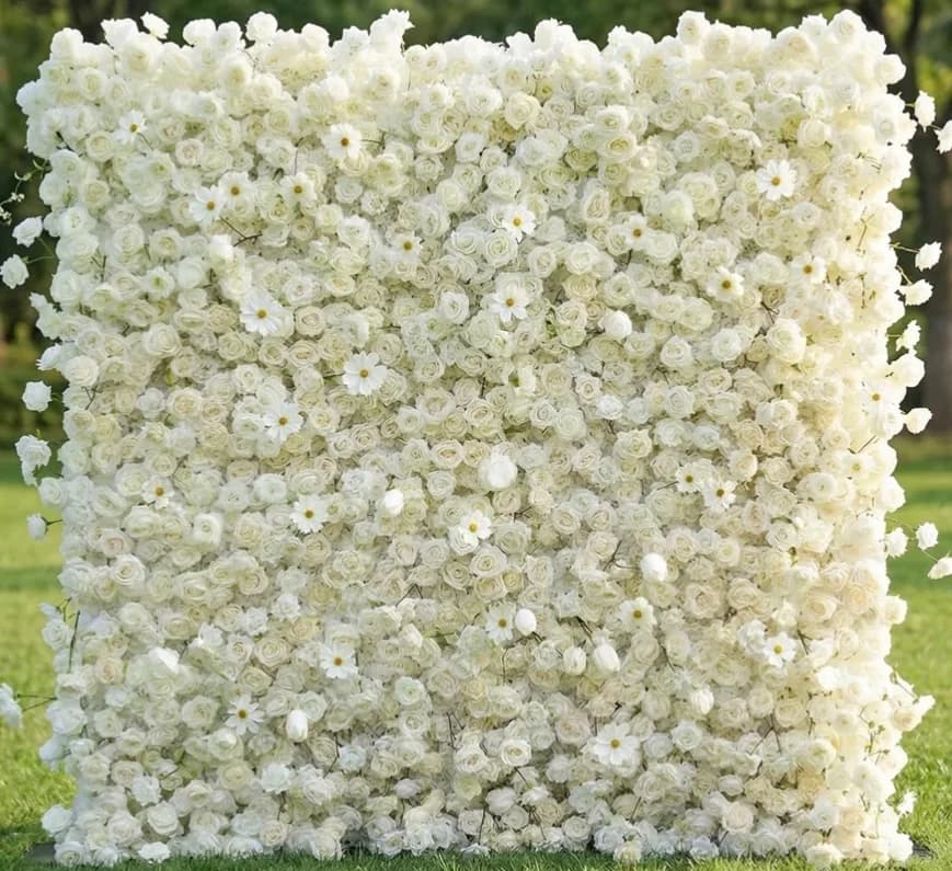 Dimensional white flower wall with roses and daisy-like flowers, photographed outdoors