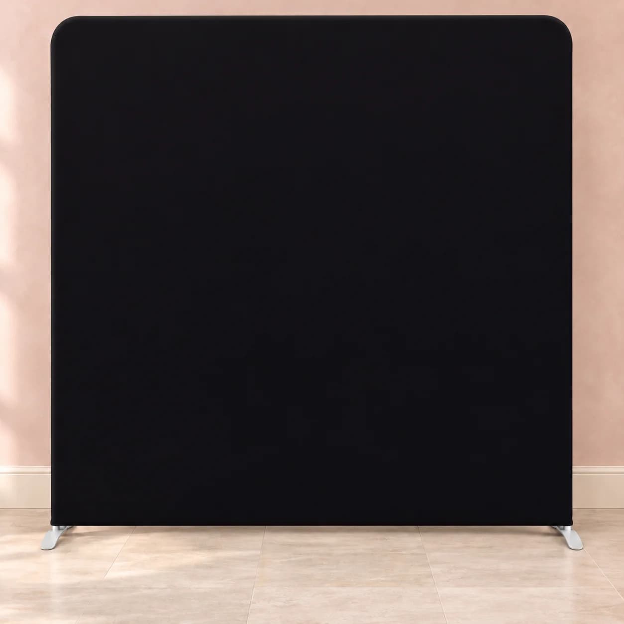 Solid black tension-fabric backdrop with two support feet in an illustrative room