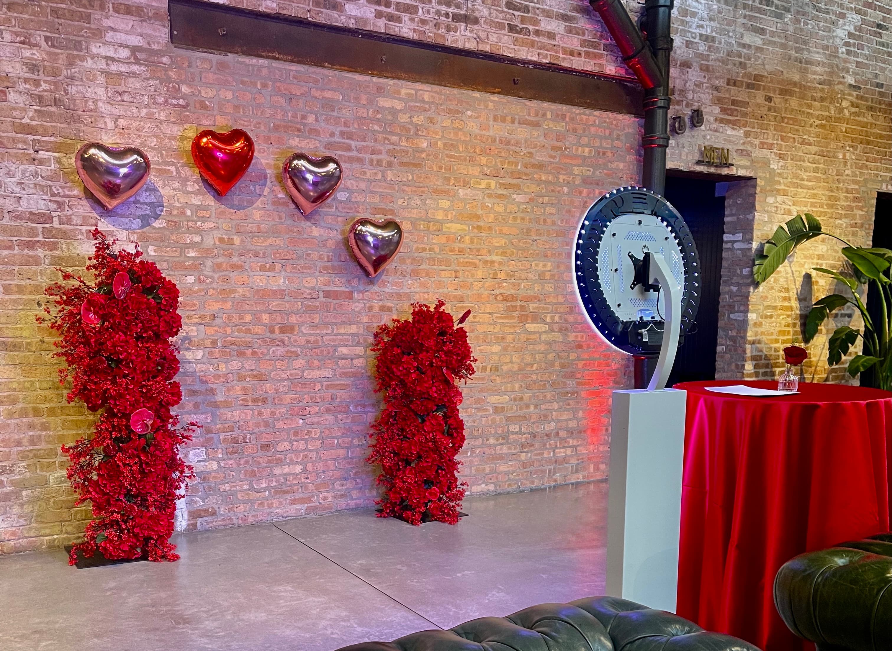 A real KandyBooth setup beside red floral letters and heart balloons at a Chicago charity event