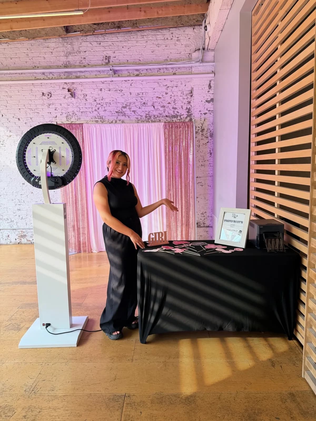 A real KandyBooth setup with its circular ring-light booth and a rose-gold and white backdrop